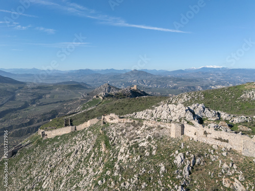 Ancient fortress ruins on a hill overlooking agricultural fields in Akrokorint, Greece
