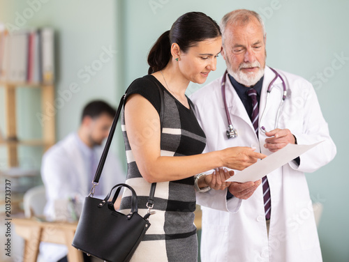 Canvastavla Senior doctor discusses medical tests with happy woman in a clinic
