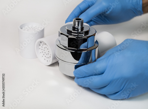 closeup view of  human hands in blue latex gloves, holding  checking  water filter for improving water quality