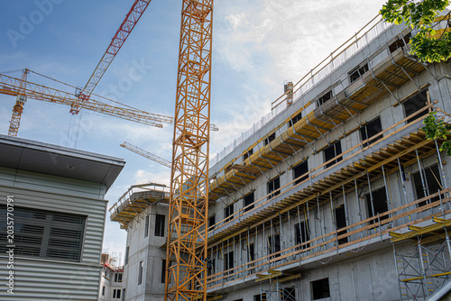 Obraz na płótnie Tower cranes and unfinished concrete building under construction