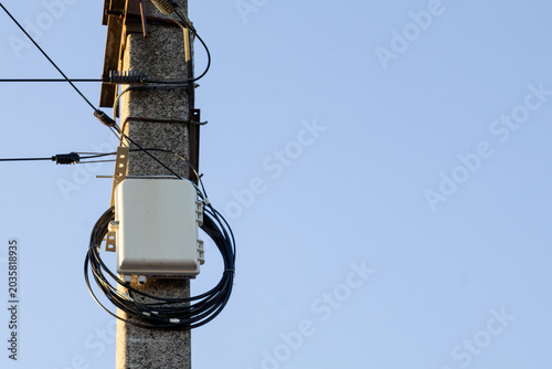 Telecommunication Equipment Installed on a Concrete Pole Against a Clear Blue Sky During the Daytime