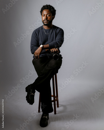 Foto Beautiful and elegant black man, photographer posing for photos in a photography