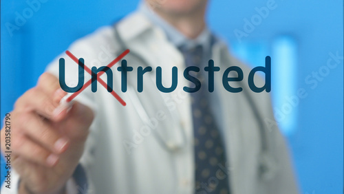 Photography Doctor's hand highlighting and crossing out untrusted word on a transparent scre