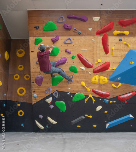 Male Climber Hanging from an Overhanging Indoor Bouldering Wall