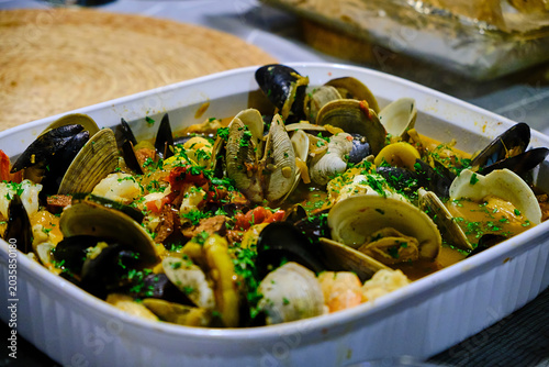 фотографія Clams and mussels cocked in a ceramic dish.