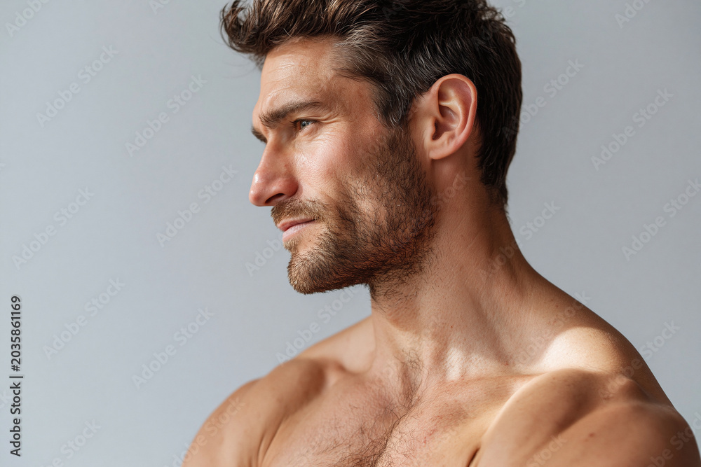Naklejka premium Handsome bearded man shoulder focus natural window light contemplative expression
