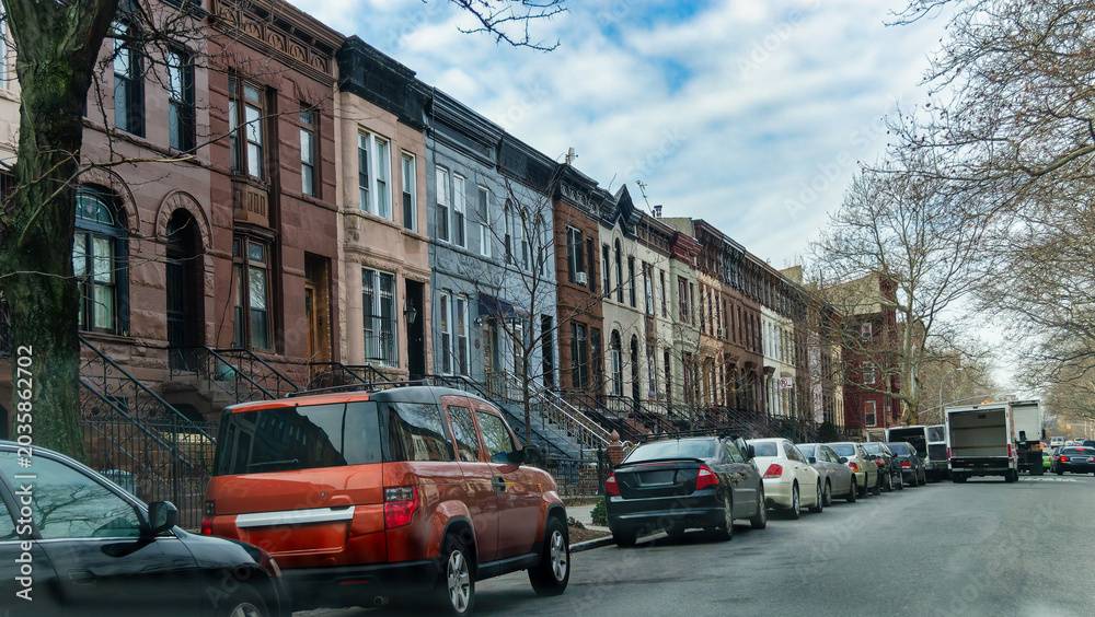 Fototapeta premium New York, US, 15 January 2015 Row Houses and Parked Cars Along an Urban Residential Street