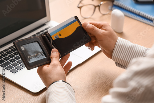 Male hands with wallet and credit cards at table, closeup