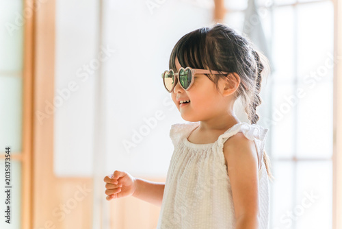 Konstfotografi A girl wearing sunglasses plays pretend as a model in a fashion show
