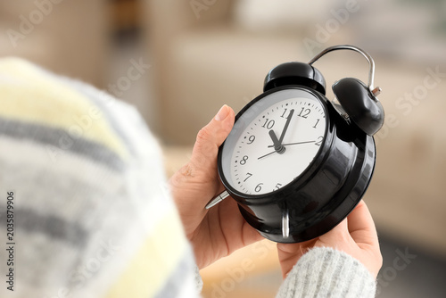Woman changing alarm clock ...