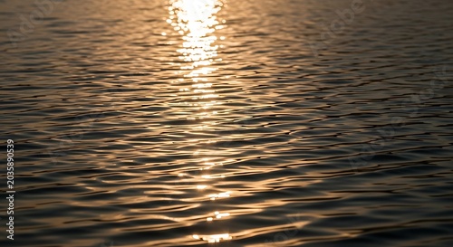Golden sunset reflection on water surface.