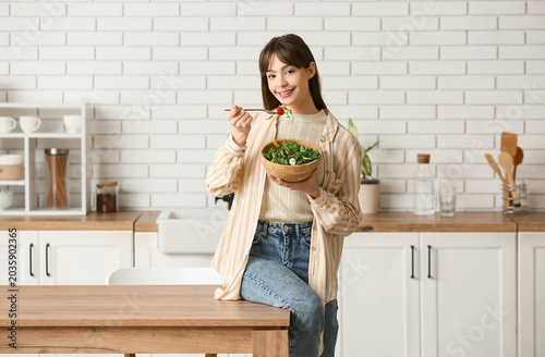 Young woman eating fresh ve...