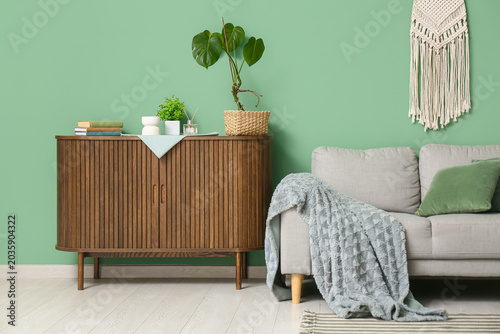 Foto Interior of living room with sofa and commode