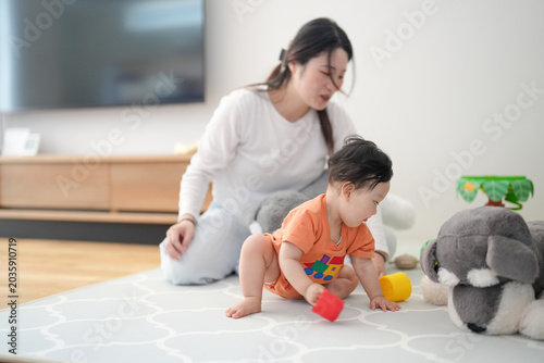 Slika na platnu Mom smiles warmly as baby plays