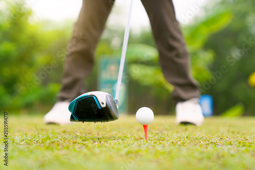 Golfer addressing - positioning the ball before tee off shot