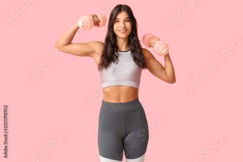 Young woman with dumbbells ...