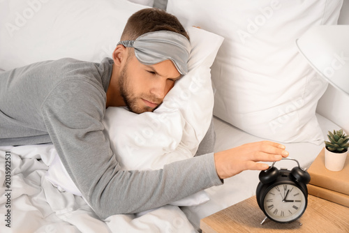 Young man in sleeping mask ...