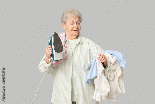 Senior woman with iron and ...