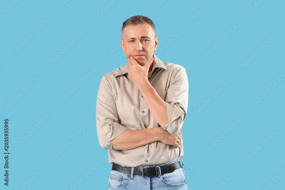 Fototapeta premium Mature man suffering from toothache on blue background