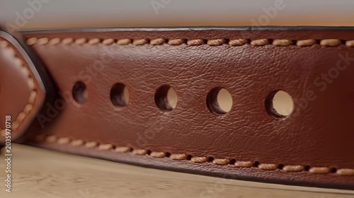 Closeup Macro Shot of a Detailed Brown Leather Belt with Stitched Edges and Metal Buckle.
