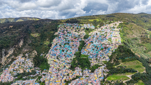 Foto A vibrant hillside community in Bogotá with multicolored houses, showcasing urban transformation under a cloudy sky