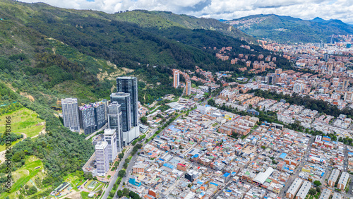 Φωτογραφία The image captures a dense urban area with high-rise buildings juxtaposed against green mountains in Bogotá, Colombia