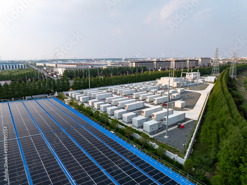 Aerial view of photovoltaic solar panels and energy storage battery containers in an industrial power station