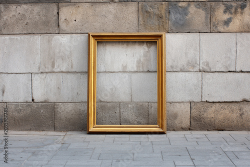 Empty vintage frame on concrete wall beside arched stone pavement street, copy space