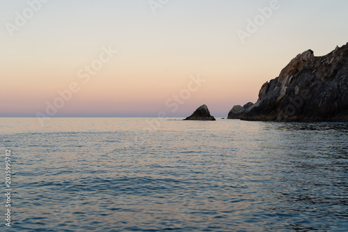 Bilde på lerret Calm sea and rocky coast at sunset. Horizontal.