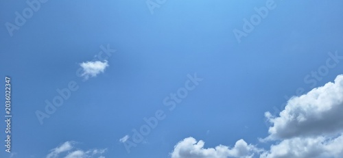 Bright blue sky with soft white cumulus clouds