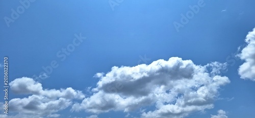 Bright blue sky with soft white cumulus clouds