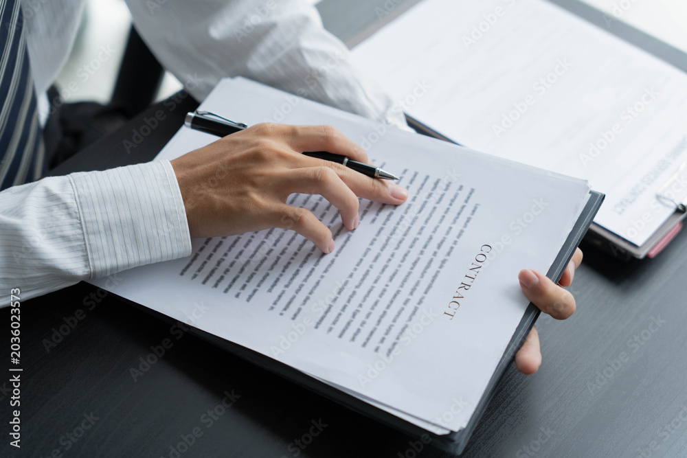 Fototapeta premium Lawyer reading legal document in office room