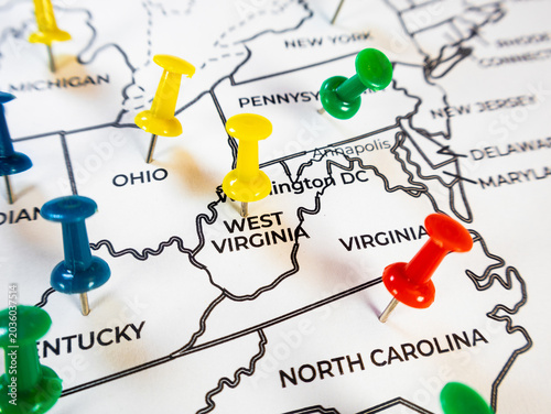 Macro close-up of an Eastern US map with colorful push pins marking North Carolina, West Virginia, Ohio, and Kentucky. Ideal for regional logistics, business tracking, demographics and travel planning