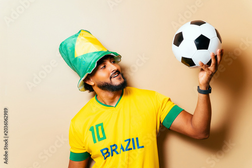 Brazil soccer fan celebrating victory holding ball