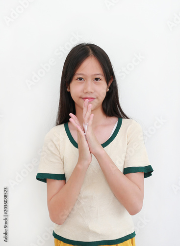 Smiling young Asian girl rubbing her hands together to apply moisturizing skin cream, isolated on white background.