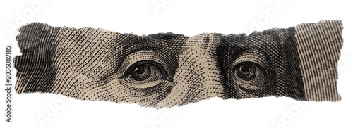 Close-up of Benjamin Franklin's Eyes on Torn Dollar Bill