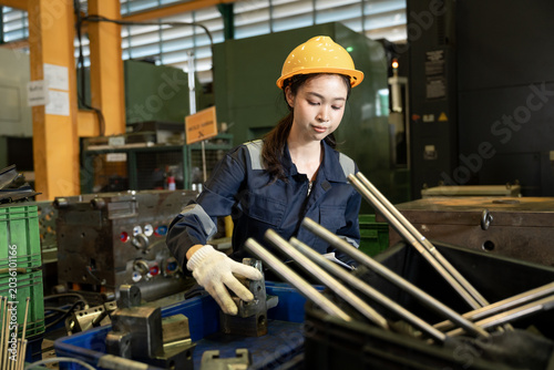 Engineer woman or worker working and checking machine in warehouse for production supply