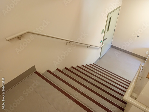 The stairwell shows safety handrails for an emergency exit in a nursing home building in Canada. The stairs lead to an exit door.