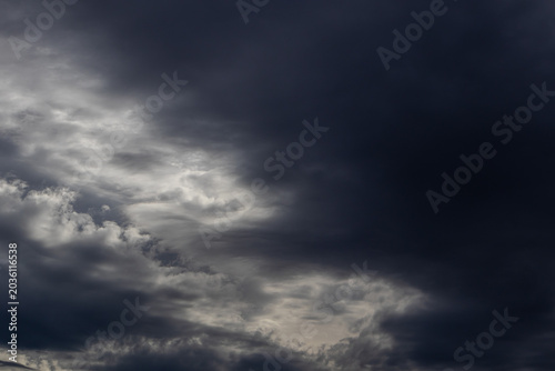 Foto Turbulent dark cloudscape with billowing storm clouds and diffused light piercin