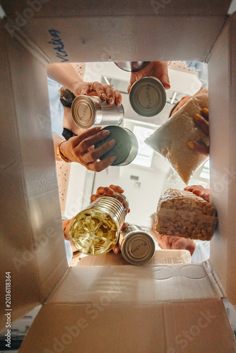 Fotografía Volunteers putting food in a donation box for charity