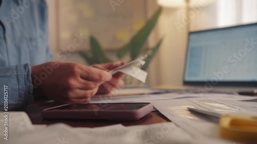 Woman sorts receipts using a calculator to track expenses at home. Budget planning or tax return from home. High quality 4k footage