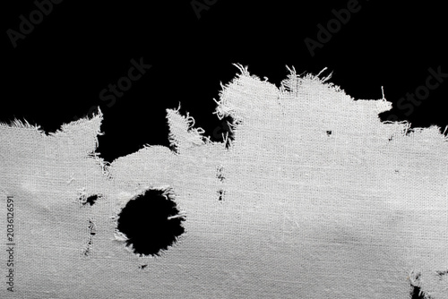 Φωτογραφία a torn old white rag, canvas with holes and fraying edges