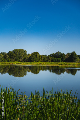 Konstfotografi a meandering lake with calm, mirror-like waters in which the landscape is reflec