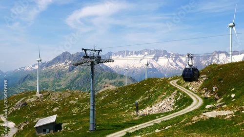 Beautiful Mountain View with a Glacier and Wind Turbine and Overhead Cable Car in the Swiss Alps in a Sunny Summer Day in Andermatt, Uri, Switzerland.