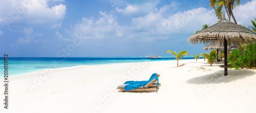 Vacation summer holidays leisure background - sunny tropical Caribbean paradise resort beach with white sand, lounger, palms on Maldive