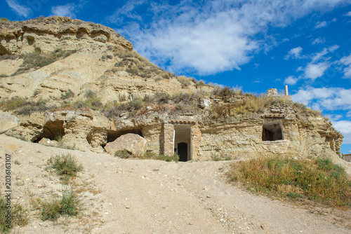 Photography view from outdoor of ancient troglodyte dwellings in cliff  in the Bardenas dese