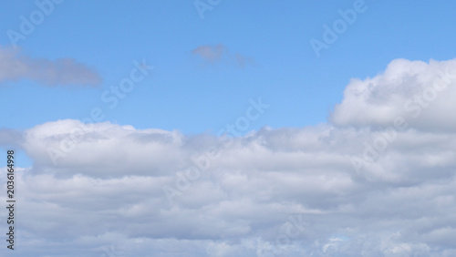 Quadro su tela Fluffy White Cumulus Clouds Drifting Across a Bright Blue Sky