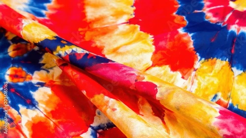 Vibrant tie-dye fabric with abstract colorful patterns in red blue and yellow hues