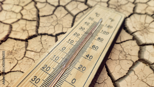 Tableau sur toile a wooden thermometer on severely cracked dry earth powerfully symbolizing extrem