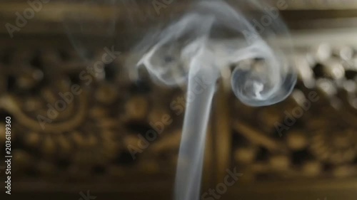 Smoke rises in a dark room with ornate decorations and lighting effects